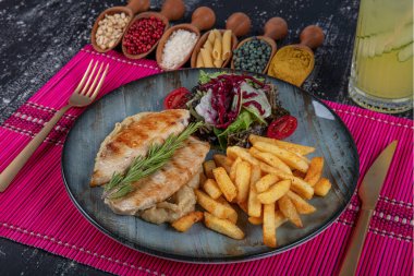 Izgara tavuk göğsü. Kızarmış tavuk fileto ve taze sebze salatası domates, salatalık ve roka yaprakları. Salatalı tavuk eti. Sağlıklı yiyecekler. Düz yatıyordu. Üst Manzara. Koyu arkaplan