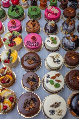 Kremalı ya da meyveli pasta satan bir pastane. Mermer tezgahta renkli güzel pastalar sergileniyor..