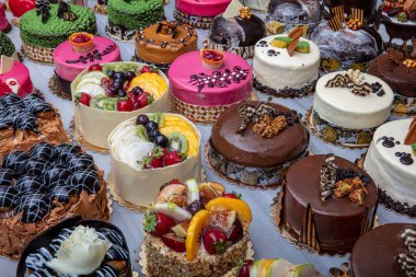 Kremalı ya da meyveli pasta satan bir pastane. Mermer tezgahta renkli güzel pastalar sergileniyor..