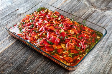 Izgarada pişmiş kırmızı biber. Kızarmış biber aperatifi. Aperatif, kavrulmuş turşu, ahşap arka planda bir kasede tatlı kırmızı biber..