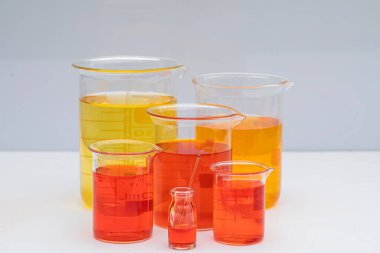 Renkli bir beher. Çözüm kimyası. Beyaz zemin üzerinde renkli sıvı bulunan laboratuvar deney şişesi..