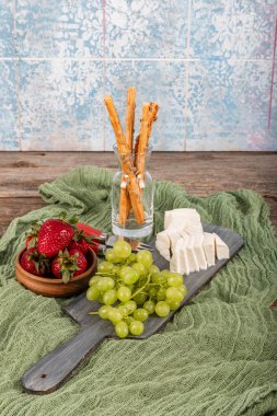 Tam yağlı inek peyniri. Kesme tahtasındaki taze peynir. Beş kiloluk plastik bir kapta beyaz peynir. Yiyecek konsepti.