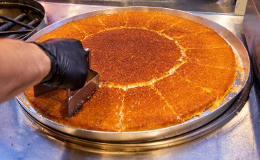 Geleneksel Türk şerbeti, Hatay kunefe, bir usta tarafından bakır kasede pişiriliyor ve ocakta döndürüyor. Hatay Kunefe 'yi kızartıyoruz. Geleneksel Türk tatlıları.