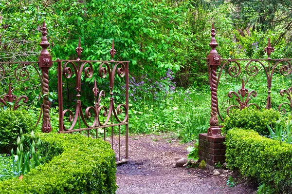 English garden with antique wrought iron gate