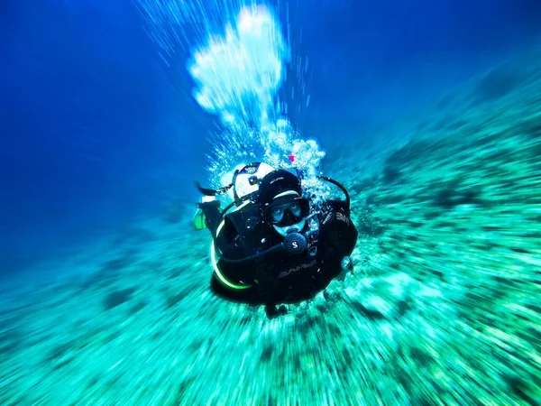 Underwater photo of scuba diver drift diving.