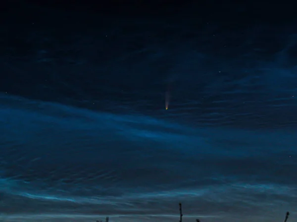 美丽的大自然背景 明亮的彗星 在深蓝色的天空中 有星星 高山上有雪峰 夕阳西下的红光照亮群山 明亮的云彩闪耀 — 图库照片