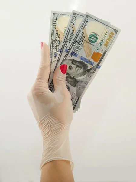 Covid 19 'u kutsa. Salgın günlerinde, kadın elinin bileşimi, elinde hijyenik eldivenlerle banknotlar tutuyordu.