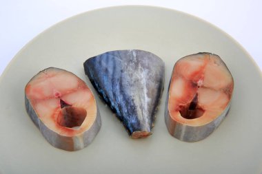 Tabakta doğranmış çiğ balık, beyaz arka planda..