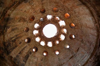 Eski ve harap bir Türk hamamı kubbesinin iç manzarası.