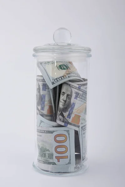 Beyaz bir arka planda, Amerikan dolarlarının kompozisyonu cam kavanozda.
