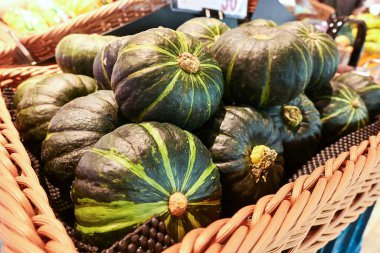 Süpermarkette rafta duran bir avuç yeşil balkabağı. Yakın çekim görünümü.