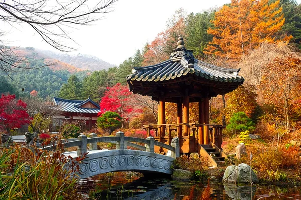 A pavilion, a stone arc bridge and a pond.