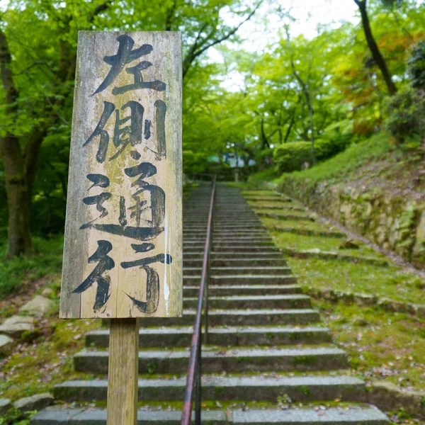 Bir tapınağın içinde Japonca işaret direği, çeviri: solda kal