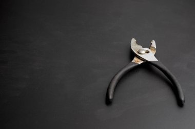 Koyu arkaplanda kopyalama alanı olan pense ve siyah renkli kauçuk saplar.