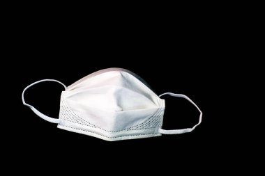 Siyah arka plandaki ağız ve burnu kapatmak için plastik kulaklıklı beyaz, temiz bir cerrahi maske. Corona virüsü covid-19 'un güvenlik maskesi.