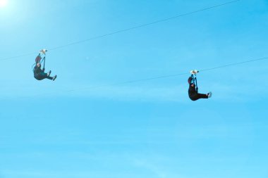 Ekstrem sporcunun hareket bulanıklığı ve yumuşak odağı parlak güneş ışığı arkaplanlı bir ipe atlıyor..