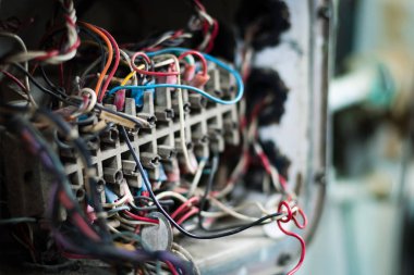 Çok renkli ve bulanık arkaplanı olan paslı, eski ve bozuk elektrik kablolarını kapatın..