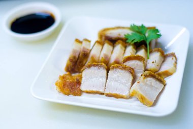 Kapalı ve seçici odak noktası. Lezzetli ev yapımı leziz leziz domuz eti. Beyaz arka planda tatlı ekşi sosla kızartılmış beyaz tabakta, Tayland geleneksel yemekleri..