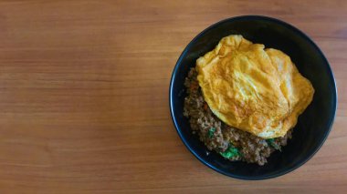 Manzaralı popüler yemekler kızarmış domuz ve biberli fesleğenli omlet ahşap masa, Tayland yemeği. Metin için alanı kopyala