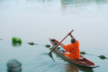 Budist keşiş, küçük bir teknede Tayland 'da kanala yelken açıyor..