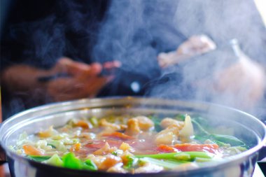 Et dilimlenmiş sığır eti ve sebzeli sıcak tencerenin yakın görüntüsü. Shabu Shabu, ince dilimlenmiş et ve sebzelerle dolu sıcak tencerede yapılan bir et türüdür. Tayland 'ın en popüler yemekleri..