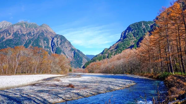 Japonya 'nın Nagano Eyaleti' nin Kuzey Japonya Alpleri 'ndeki temiz su nehri ile sonbahar yaprağındaki güzel dağ manzarası.