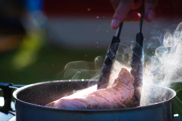 Close Chef Mão Com Pinças Segurando Carne Fritar Ferro Fundido — Fotografia de Stock