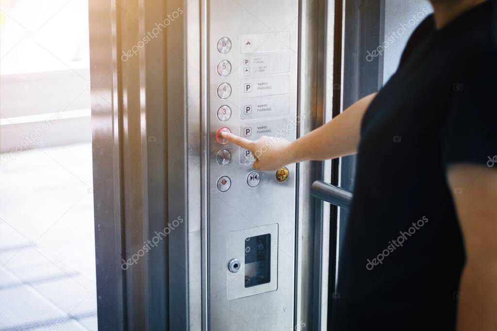 Woman use finger presses the elevator button