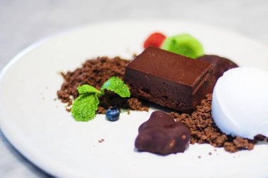 Tatlı, kahverengi çikolata ve nane yapraklı vanilyalı dondurma parçalarını kapayın..