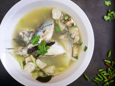 Baharatlı Uskumru Çorbası (Tom Yum Pla Tu) Tayland geleneksel yerel yemekleri koyu arka planda beyaz kasede, baharatlı sıcak ve ekşi otlu çorba.