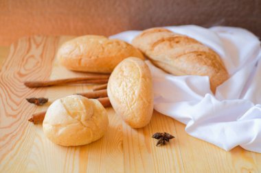 Tahta masada beyaz kumaşlı taze, nefis kahvaltı ekmeği..
