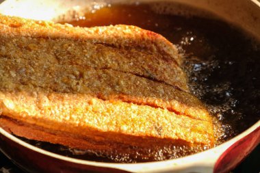 Kızarmış domuz eti pişiriyorum. Sıcak yağın üstünde, beyaz tavada, güneş ışığıyla. .