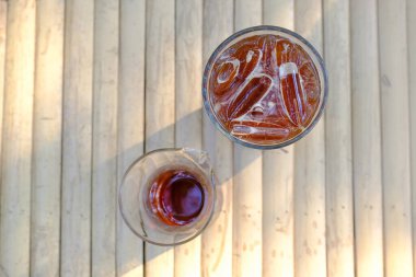 Bambu ahşap arka planda buzlu, gölgeli ve güneşli kahve çayı manzarası..