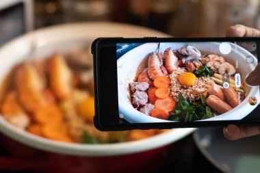 Baharatlı hazır şehriye çorbası (tom yum yum yum) deniz ürünleri karides, midye, sosis, domuz pirzolası, yumurta sarısı, akıllı telefondan görüş..