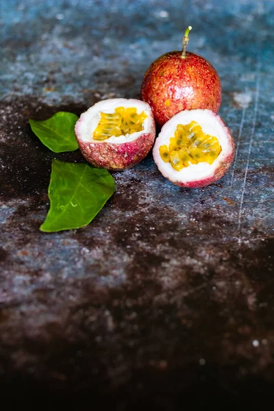 Fresh Tropical Passion Fruits on dark grunge background top view flat lay with copy space for background or wallpaper. Ripe passion fruit so sweet and sour. Tropical fruit.