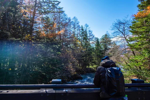 在日本神户度假的时候 年轻的背包客站在桥上观赏美丽的自然河流蓝天风景 放松心情 — 图库照片