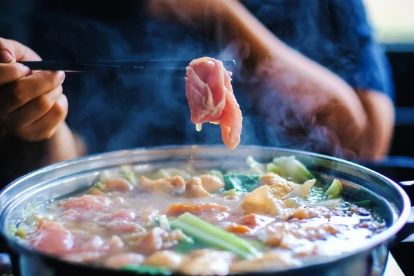 젓가락으로 쇠고기 고기를 여성은 고기와 야채를 뜨거운 남비에 한국인이나 일본인 — 스톡 사진