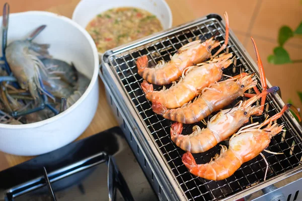 Üst düzey karides grubu kömür ocağında ızgara yapıyor. Deniz ürünleri pişirmek bbq parti açık havada kamp.