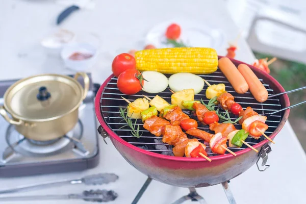 Açık havada domuz eti, sosis, domates, soğan, ananas, biber ve mısırlı renkli barbekü..