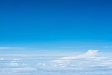 Güneşli bir günde, tropikal yaz ikliminde, parlak mavi gökyüzünün arka planında, muhteşem doğal bulut manzarası inanılmaz beyaz kümülonimbus bulutları, mavi gökyüzü ve üst bulut manzarası ya da uçaktan kuş bakışı bulutlar.