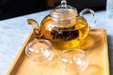 Çaydanlıkta çay yaprağı ve masada fincan olan sıcak su. Çay demleme süreci, çay seremonisi, bir fincan taze demlenmiş çay, Çay molası..