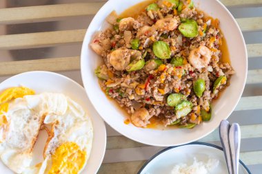 Geleneksel Tayland usulü baharatlı kızarmış karides, acı ya da bükülmüş fasulye ya da kokulu fasulye (sataw) ve ahşap masada karides ezmesi, Güney Tayland yemeği..