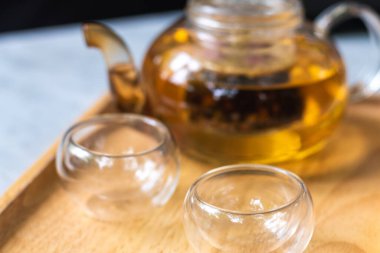 Masanın üzerinde çaydanlık arkaplanı olan bir fincan çay. Çay demleme süreci, çay seremonisi, bir fincan taze demlenmiş çay, çay molası..