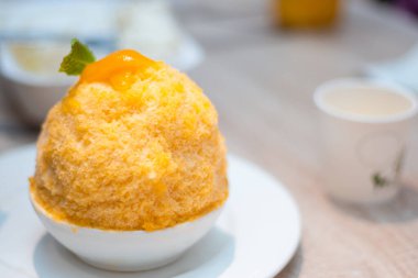 Thai sütlü çayını beyaz tabakta, Bingsu ya da Bingsoo Kore usulü, tatlı soslu ve meyveli buzlu tatlı..