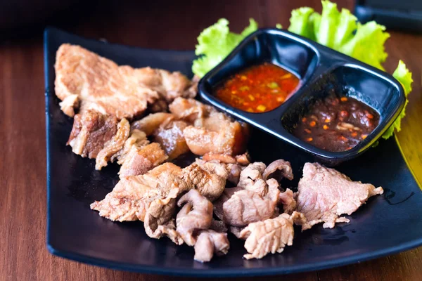 Pişmiş haşlanmış domuz eti, siyah tabakta et, tatlı ve baharatlı biber sosuyla yenir. Tayland tarzı yemek..