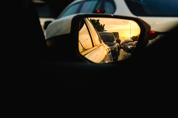 Bangkok Traffic jam of cars in rush hours evening with sunlight , view from side mirror of car.