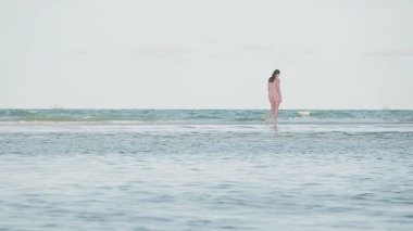 Yaz tatilinin tadını çıkaran güzel, mutlu genç bir kadın Tayland 'daki Hua Hin kumlu plajında yürüyor.