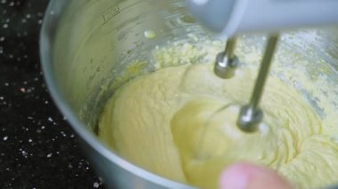 Şef kek pişirmek için malzemeyi un yumurta yağı ve şekerle karıştırma makinesinde karıştırıyor. Mutfakta tatlı yemek hazırlıyorum. 