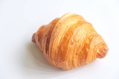 Beyaz arkaplanda taze kruvasan var..