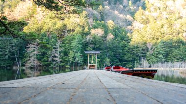 Myojin-Ike Pond 'daki kırmızı Shinto Tapınağı ve tekneleri ile doğanın güzel manzarası Hotaka Tapınağı, Kamikochi, Japonya